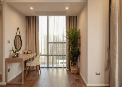 A well-lit bedroom with a modern vanity setup and indoor plant