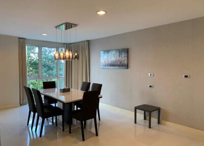 Modern dining room with a stylish table, six chairs, and a contemporary light fixture