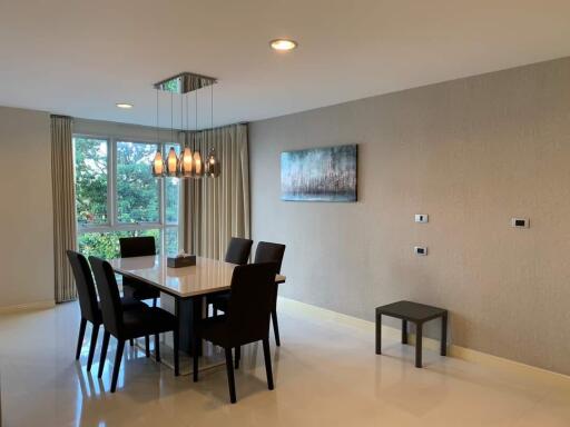 Modern dining room with a stylish table, six chairs, and a contemporary light fixture