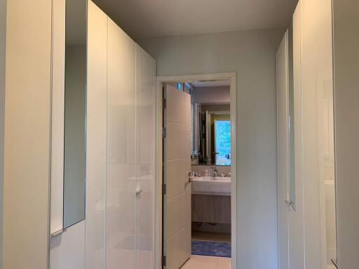 View of a bathroom with white cabinets and a sink