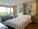 Spacious bedroom with large windows, double bed, and sitting area