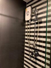 Modern bathroom with black and white striped tiles and a shower unit