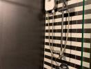 Modern bathroom with black and white striped tiles and a shower unit