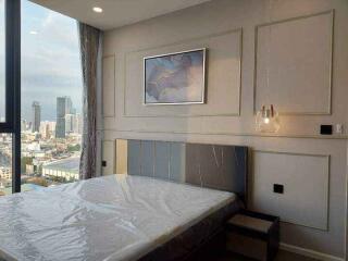 Modern bedroom with a large window and city view