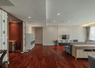 Spacious living room with wooden flooring, modern furniture, and large windows