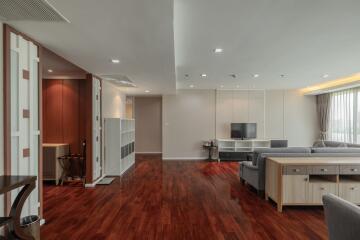 Spacious living room with wooden flooring, modern furniture, and large windows