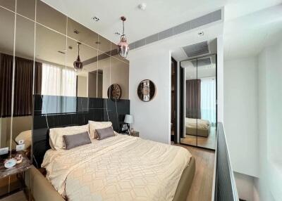 Modern bedroom with mirrored wall and king-size bed