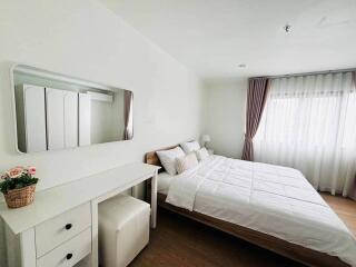 Spacious bedroom with a double bed, bedside table, and dressing table