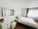 Spacious bedroom with a double bed, bedside table, and dressing table