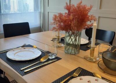 Dining area with table set for a meal, featuring views of cityscape