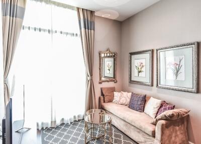 Bright and cozy living room with a sofa, wall art, and a glass table.