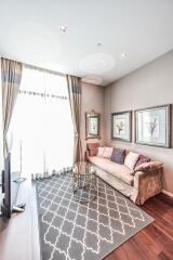 Bright and cozy living room with a sofa, wall art, and a glass table.