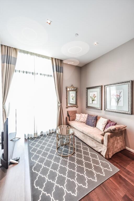 Bright and cozy living room with a sofa, wall art, and a glass table.