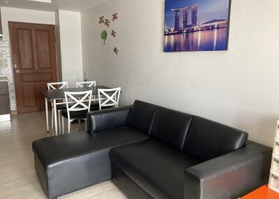 Living room with black leather sofa and dining table