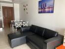 Living room with black leather sofa and dining table