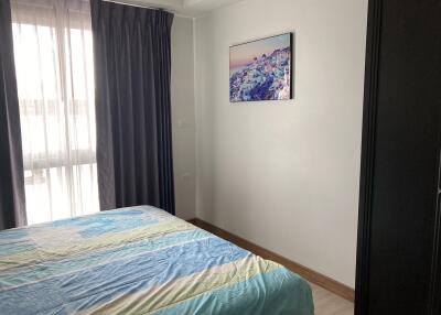 Bedroom with a bed, window, and wall art