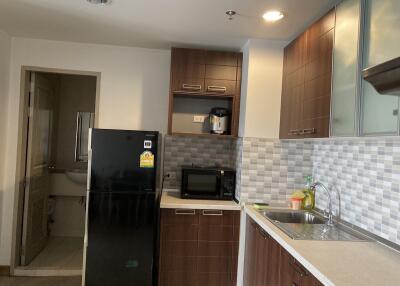 Modern kitchen with black fridge, microwave, and sleek cabinetry