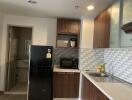 Modern kitchen with black fridge, microwave, and sleek cabinetry