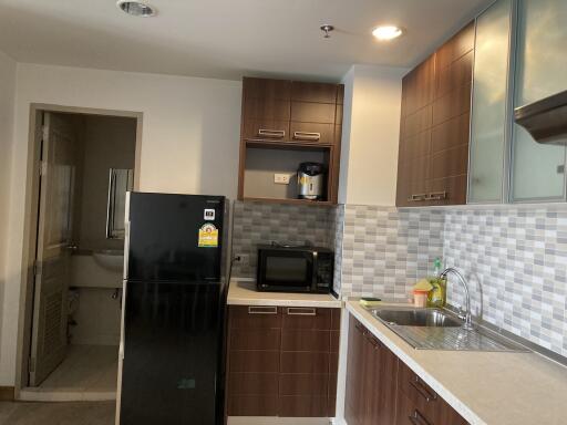 Modern kitchen with black fridge, microwave, and sleek cabinetry