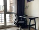 Workspace with desk, chair, lamp, and artwork near balcony