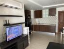 Modern kitchen with wooden cabinets, TV, and dining area