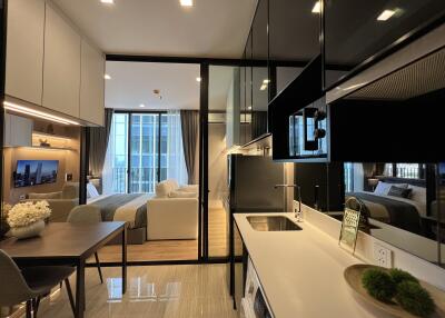 Modern open-concept living space with kitchen, dining area, and bedroom