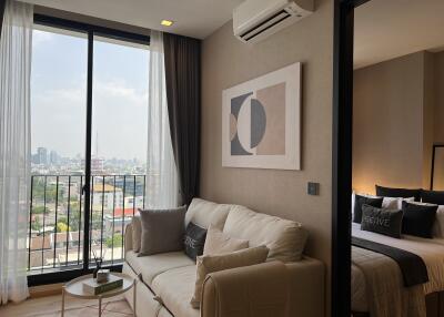 Living room with sofa, wall art, and view of the city