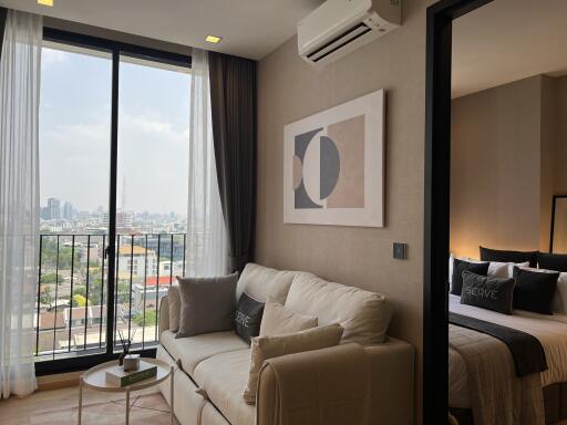 Living room with sofa, wall art, and view of the city