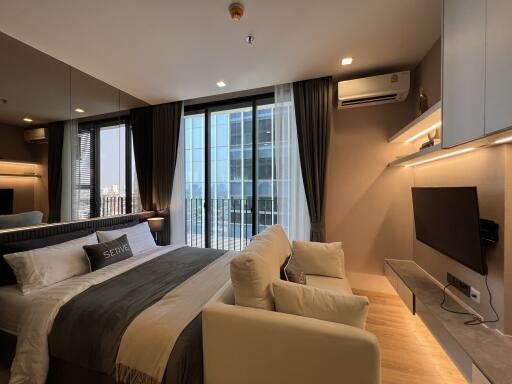 Modern bedroom with large windows and city view