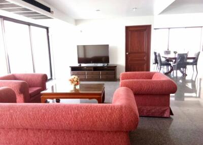 Spacious living room with red sofas and TV