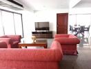 Spacious living room with red sofas and TV