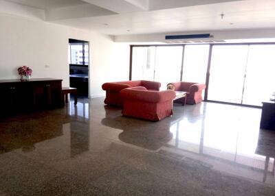 Spacious living room with red sofas and large windows