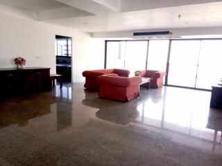 Spacious living room with red sofas and large windows