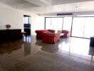 Spacious living room with red sofas and large windows