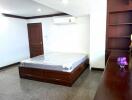 Spacious bedroom with a double bed, built-in shelves, and an air conditioning unit