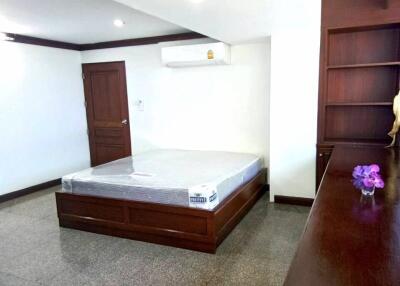 Spacious bedroom with wooden furniture and built-in shelving