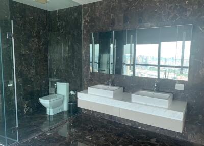 Modern bathroom with double sinks, large mirror, and glass-enclosed shower