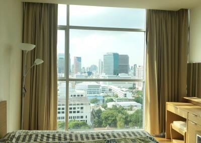 Bright bedroom with large window and city view