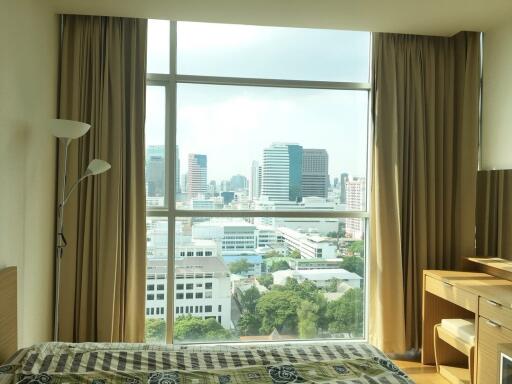 Bright bedroom with large window and city view