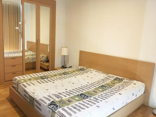 Bedroom with large bed and mirrored wardrobe