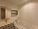 Modern bathroom with a bathtub, sink, and mirror