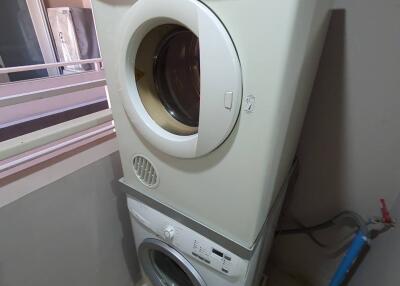 Stacked white washer and dryer in a laundry area