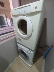 Stacked white washer and dryer in a laundry area