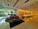 Modern living area with large glass walls, contemporary furniture, and recessed lighting