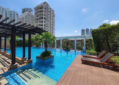 Luxurious swimming pool in a high-rise condominium complex with sun loungers