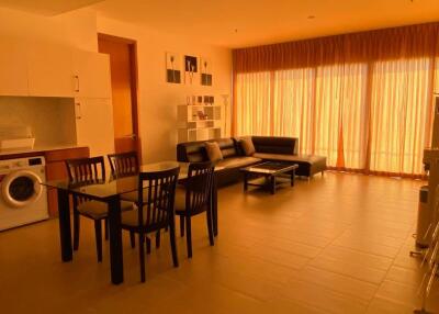 Modern living area with dining table, sofa, and large windows