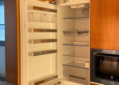 Open fridge and wooden cabinets in a modern kitchen