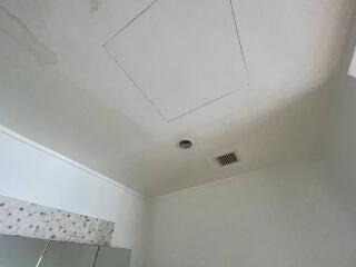 Bathroom ceiling with water stains and vent