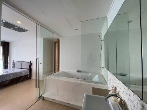 Modern bathroom with a view of the bedroom and glass shower