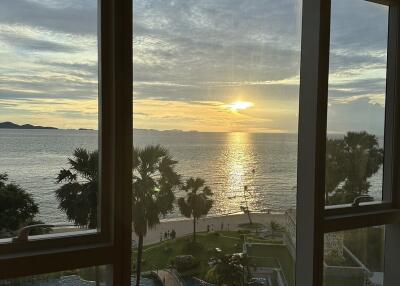 A stunning seaside view from the apartment with a visible swimming pool.